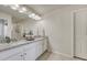 Bathroom with dual sinks, white cabinetry, granite countertops, large mirror, and modern lighting fixture above at 3793 Cadence Dr, Castle Rock, CO 80109