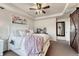 Cozy bedroom with tray ceiling, ceiling fan, chic decor, and a decorative sliding barn door at 3793 Cadence Dr, Castle Rock, CO 80109
