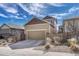 Two-car garage with concrete driveway and tasteful landscaping, complemented by a blue sky at 3793 Cadence Dr, Castle Rock, CO 80109