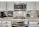 Close-up of the kitchen featuring stainless steel appliances, granite countertops, and white subway tile backsplash at 3793 Cadence Dr, Castle Rock, CO 80109