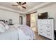 Bedroom featuring ceiling fan, barn door to bathroom, and dresser with TV at 3793 Cadence Dr, Castle Rock, CO 80109