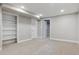 Basement with neutral carpet, white trim, and built-in shelving at 5553 S Datura St, Littleton, CO 80120