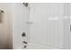 Shower featuring stylish subway tile, glass shelf, and modern fixtures at 5553 S Datura St, Littleton, CO 80120