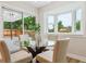 Bright dining area with glass table, and sliding glass doors providing access to a covered outdoor deck at 5553 S Datura St, Littleton, CO 80120