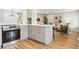Bright, modern kitchen featuring stainless steel appliances, gray cabinetry, and an open layout to the living area at 5553 S Datura St, Littleton, CO 80120
