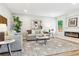 Inviting living room with a fireplace and views to the kitchen area at 5553 S Datura St, Littleton, CO 80120