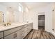 Bathroom with double sinks, long vanity, large mirrors, and walk-in closet with built-ins at 918 Promenade Dr, Superior, CO 80027