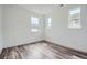 Bright bedroom featuring hardwood floors, three windows, and white walls at 918 Promenade Dr, Superior, CO 80027