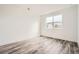 Empty bedroom with wood-look floors, white walls, and a large window at 918 Promenade Dr, Superior, CO 80027