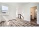 Spacious living room with hardwood floors, a window, and a doorway leading to the bathroom at 918 Promenade Dr, Superior, CO 80027