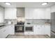 Modern kitchen with stainless steel appliances, granite countertops, and ample white cabinetry at 1150 S Taos Way, Denver, CO 80223