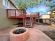 Spacious backyard featuring an elevated wood deck, stairs, a fire pit, and privacy fence at 542 Hawthorn Cir, Frederick, CO 80530