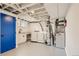 Basement laundry area with new washer, dryer, and utility sink with bright blue door at 5971 S Crestview St, Littleton, CO 80120