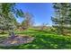 Serene backyard featuring a comfortable bench, lush lawn, and fence with picturesque views at 11257 W Radcliffe Dr, Littleton, CO 80127
