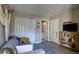 Cozy bedroom featuring a comfortable sofa, closet, and convenient access to an adjacent room at 11257 W Radcliffe Dr, Littleton, CO 80127
