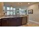 Open kitchen with stainless steel appliances, granite countertops, and view to a living room with large windows at 11257 W Radcliffe Dr, Littleton, CO 80127