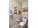 A view of a powder room with a toilet and framed art on the wall at 11257 W Radcliffe Dr, Littleton, CO 80127