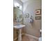 Charming powder room featuring a pedestal sink, decorative mirror and coordinated art at 11257 W Radcliffe Dr, Littleton, CO 80127