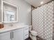 Modern bathroom with a sleek vanity, large mirror, and stylish shower curtain at 3948 Wyandot St, Denver, CO 80211