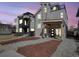 Modern home with a stone tower, wooden porch, balcony, manicured landscaping, and contemporary architectural details at 3948 Wyandot St, Denver, CO 80211