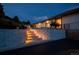 Landscaped backyard with illuminated steps that lead to upper patio with comfortable seating, perfect for evening relaxation at 1140 Lake Gulch Rd, Castle Rock, CO 80104