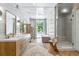 Bright bathroom with double vanity, walk-in shower, soaking tub, skylight, and marble tiling at 1140 Lake Gulch Rd, Castle Rock, CO 80104