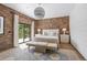Inviting bedroom featuring brick accent wall, herringbone floors, and a sliding glass door leading to outdoor space at 1140 Lake Gulch Rd, Castle Rock, CO 80104
