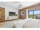 Bright bedroom with exposed brick wall, TV, white dresser, and balcony access, offering scenic views at 1140 Lake Gulch Rd, Castle Rock, CO 80104
