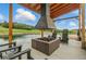 Outdoor fireplace with a cabana offering a cozy gathering place with seating near a tranquil pond at 1140 Lake Gulch Rd, Castle Rock, CO 80104