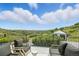 Relaxing backyard deck with comfortable seating, potted plants, and scenic views of rolling hills and blue sky at 1140 Lake Gulch Rd, Castle Rock, CO 80104