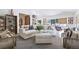 Bright living room features white sofas, textured rug, shelving and windows with stylish window coverings at 1140 Lake Gulch Rd, Castle Rock, CO 80104
