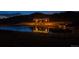 Scenic pond at night with a cozy cabana that is lit and reflected beautifully in the water at 1140 Lake Gulch Rd, Castle Rock, CO 80104