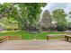 Inviting backyard with a wooden deck, bench seating, mature trees and landscaping at 10883 Otis Cir, Westminster, CO 80020