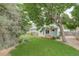 Backyard features a wooden deck, bench seating, mature trees and a green lawn at 10883 Otis Cir, Westminster, CO 80020