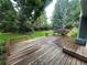 This home features a spacious wooden deck and park-like backyard with lush green grass and mature trees at 10883 Otis Cir, Westminster, CO 80020