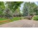 Inviting backyard features a wooden deck, bench seating, mature trees and green landscaping at 10883 Otis Cir, Westminster, CO 80020