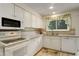 Classic kitchen featuring white cabinetry, modern appliances, and a sink with a window view at 10883 Otis Cir, Westminster, CO 80020