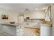 Bright kitchen featuring white appliances, granite countertops, and a functional island with open shelving at 10883 Otis Cir, Westminster, CO 80020