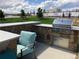 Stone outdoor kitchen featuring stainless steel appliances, bar seating, and a built-in grill at 5578 Inland Ave, Firestone, CO 80504