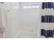Bright bathroom featuring white tiled walls and shower with stylish striped curtain at 7664 S Ivanhoe Way, Centennial, CO 80112