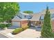 Inviting home with brick accents, a garage, and a cozy front porch area at 7664 S Ivanhoe Way, Centennial, CO 80112