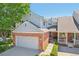 Charming townhome featuring a brick facade, attached garage, and well-manicured landscaping at 7664 S Ivanhoe Way, Centennial, CO 80112