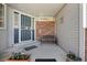Inviting covered front porch with bench seating and decorative planters and secure storm door at 7664 S Ivanhoe Way, Centennial, CO 80112