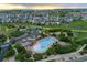 Aerial view of a community pool, clubhouse, surrounded by green spaces and residential homes at 1315 Sidewinder Cir, Castle Rock, CO 80108