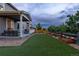 Well-maintained backyard with artificial turf, a covered patio, and a charming wooden fence with decorative lighting at 1315 Sidewinder Cir, Castle Rock, CO 80108