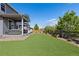 Expansive backyard with artificial turf, a covered patio, and mature trees at 1315 Sidewinder Cir, Castle Rock, CO 80108