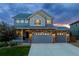 Inviting two-story home with a stone facade and well-manicured lawn, bathed in the warm glow of twilight at 1315 Sidewinder Cir, Castle Rock, CO 80108