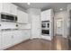 Well-lit kitchen with stainless steel appliances, white cabinets, and a view of the bathroom at 1315 Sidewinder Cir, Castle Rock, CO 80108