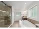 Modern bathroom features a glass enclosed shower, soaking tub with tile surround, and vanity with granite countertop at 3322 W 26Th Ave, Denver, CO 80211