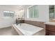 Contemporary bathroom boasting a soaking tub with tile surround, dual-sink vanity, and natural light from the window at 3322 W 26Th Ave, Denver, CO 80211